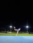 Atleta de atletismo femenino lanzando disco en el estadio por la noche - foto de stock