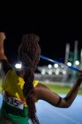 Female track and field athlete with black braids throwing javelin — Stock Photo