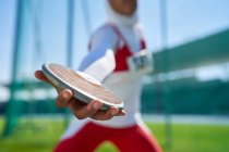 Close up female track and field athlete throwing discus — Stock Photo