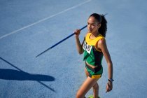Female track and field athlete preparing to throw javelin on track — Stock Photo