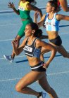 Atletas de pista e campo do sexo feminino correndo em pista ensolarada — Fotografia de Stock
