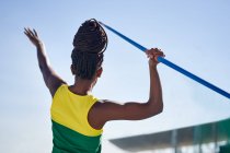 Female track and field athlete throwing javelin — Stock Photo