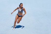 Leichtathletin auf sonnenblauer Bahn — Stockfoto