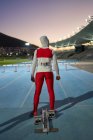 Feminino atletismo atleta em hijab no início do bloco na pista — Fotografia de Stock