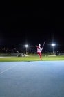 Feminino pista e campo atleta jogando dardo no estádio à noite — Fotografia de Stock