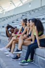 Feliz pista femenina y atletas de campo en gradas de estadio - foto de stock