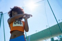 Determined female track and field athlete throwing discus — Stock Photo