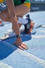 Крупним планом жіночий трек і польовий спортсмен на стартовому блоці — стокове фото