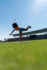 Female track and field athlete throwing shot put in sunny stadium — Stock Photo