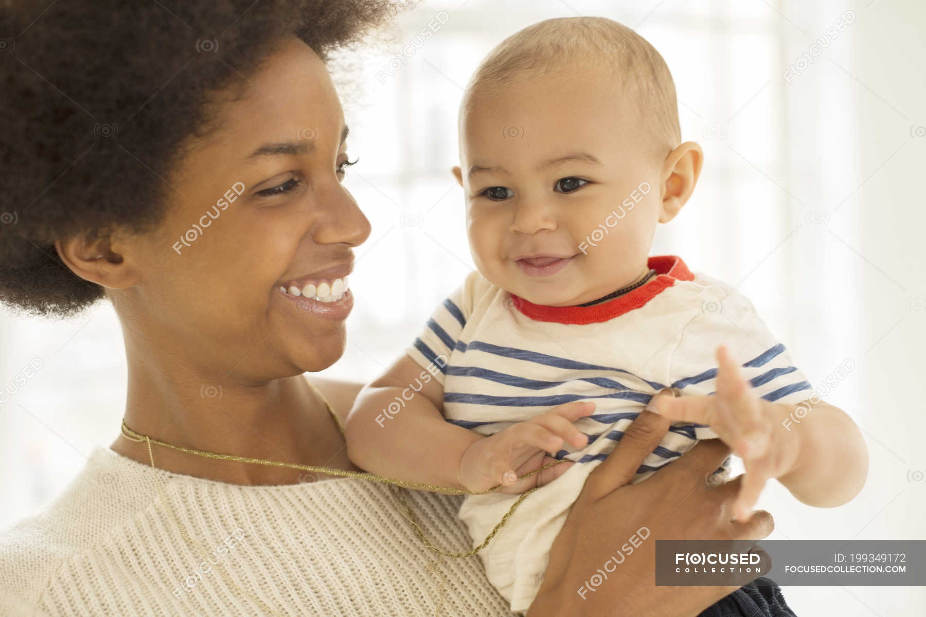 mother-holding-baby-boy-at-home-enjoyment-close-up-stock-photo