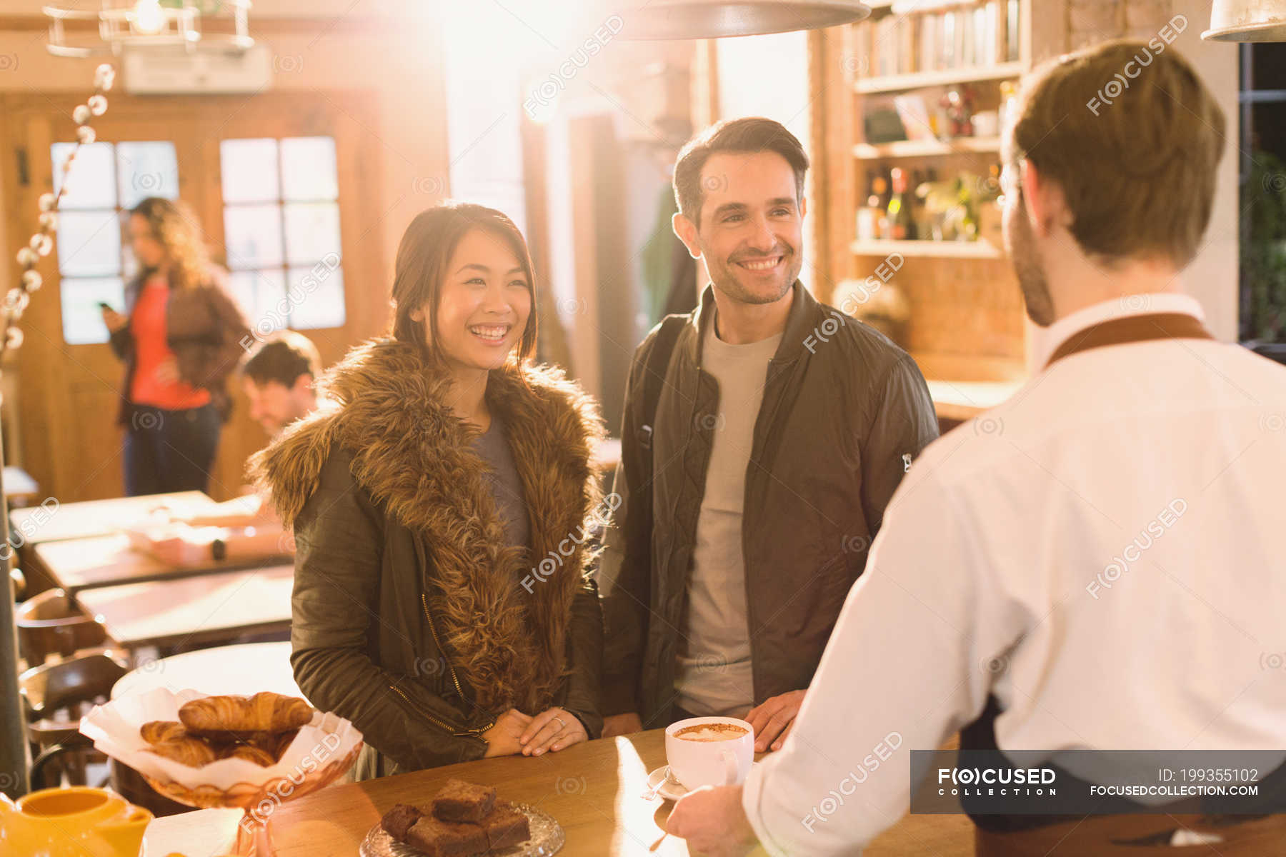 Barista serving coffee to couple at counter in cafe — skill, boyfriend
