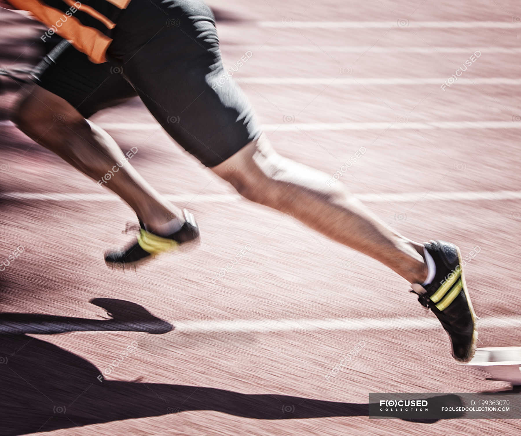 Sprinter taking off from starting block on track — Track and field athlete, one person Stock