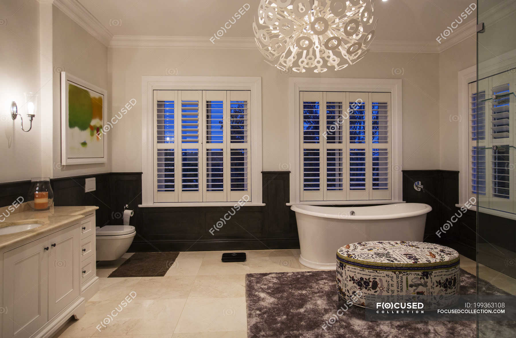 Soaking Tub And Modern Chandelier In Luxury Bathroom At Night