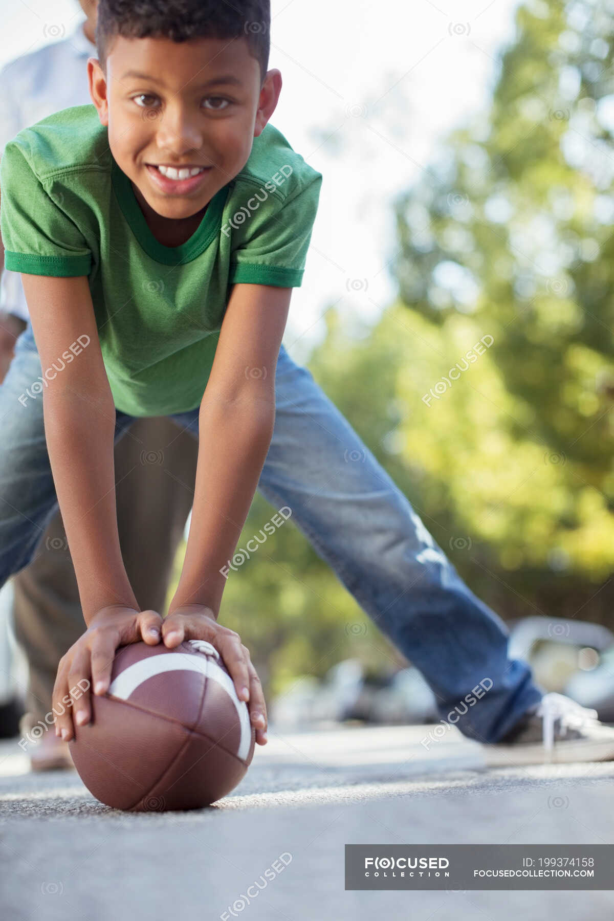 Portrait of smiling boy preparing to snap football — Color Image ...