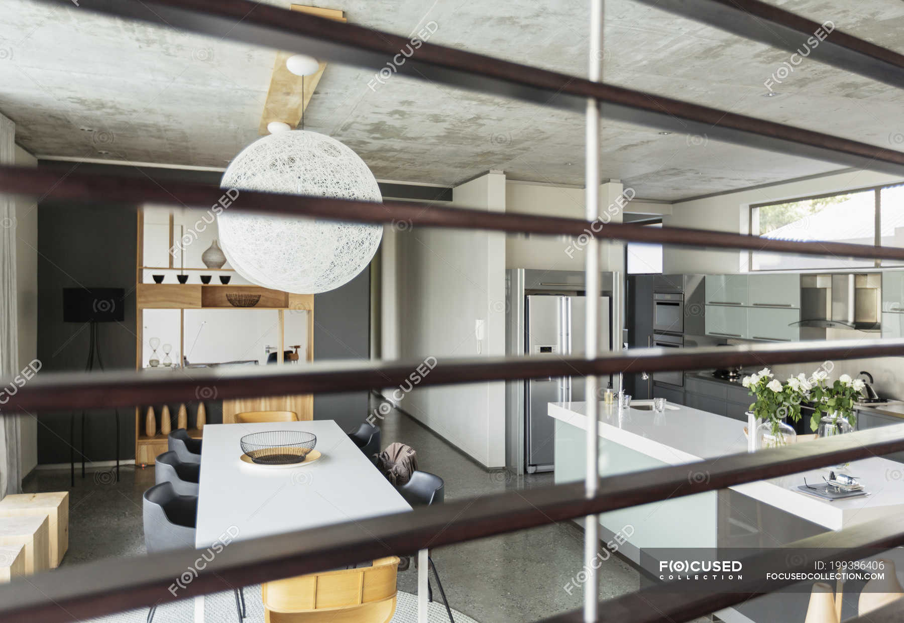 View Of Modern Dining Room And Kitchen Through Wood Slats