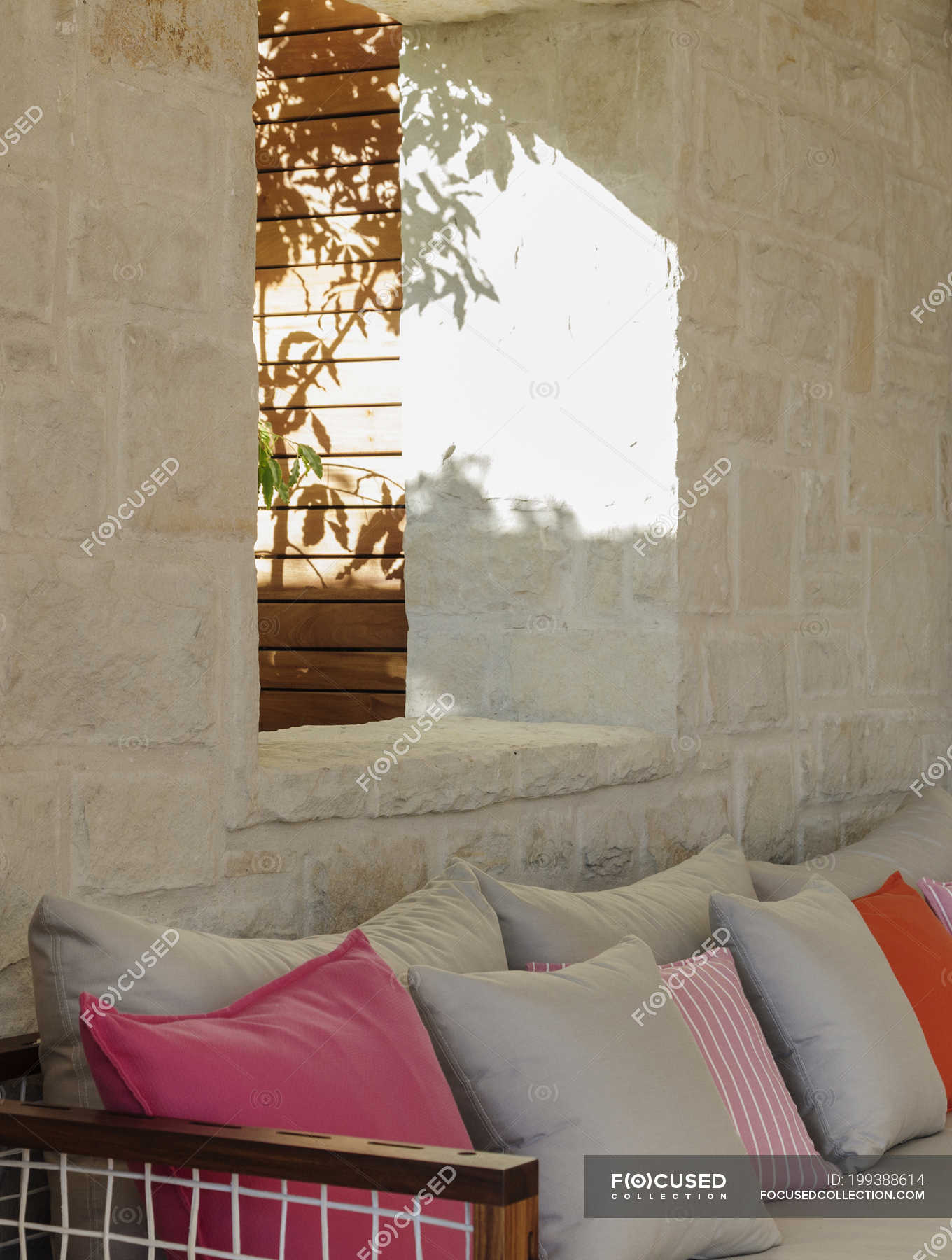 Stone Wall Behind Patio Bench With Cushions Tranquil Scene Copy