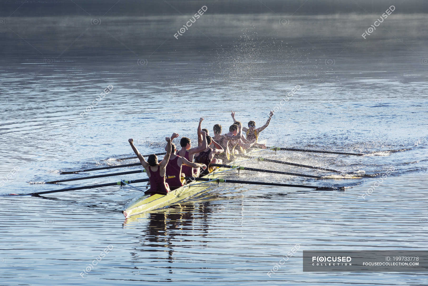 Rowing team celebrating in scull on lake — olympic, oars Stock Photo