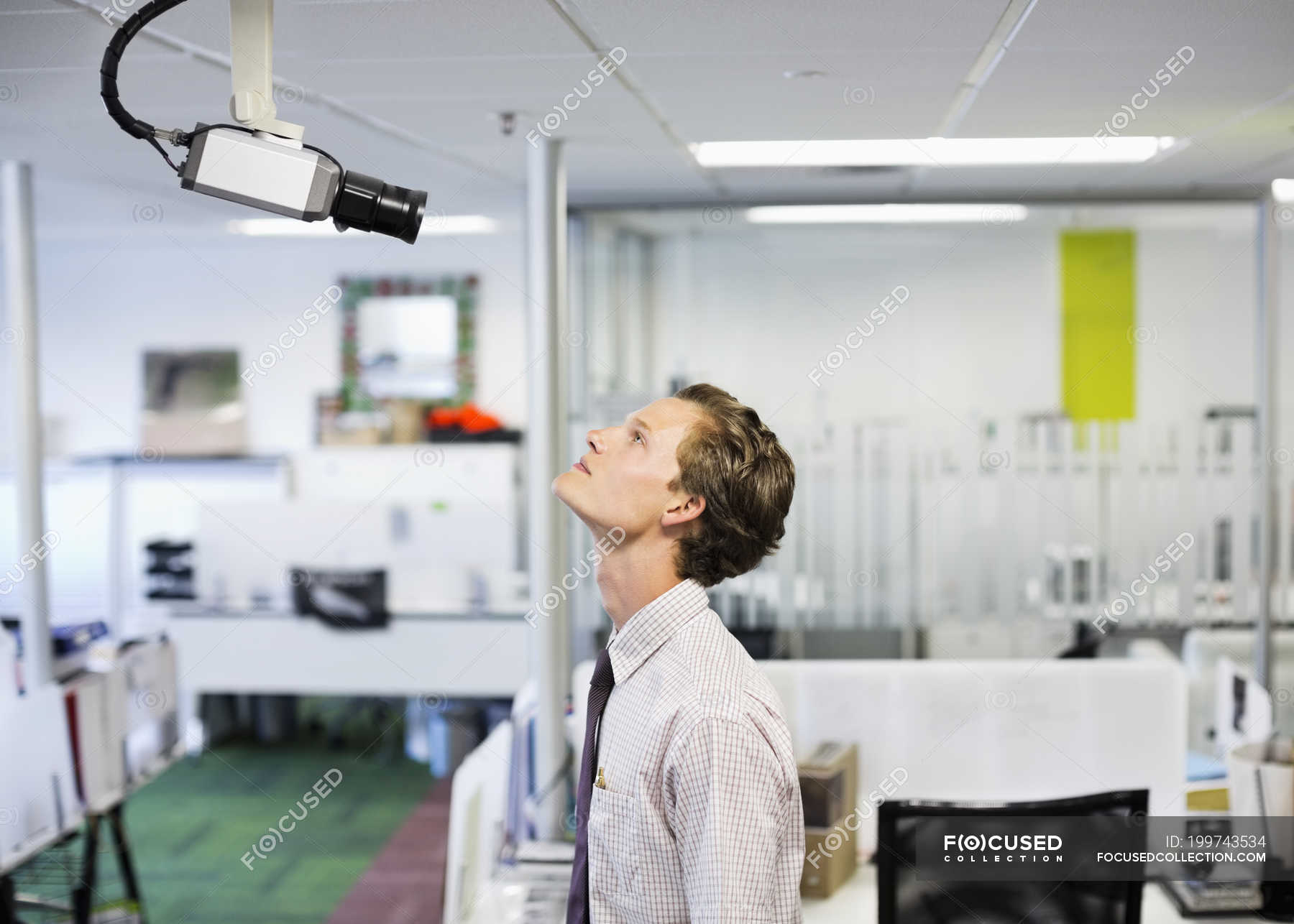 Businessman examining security camera in office — serious, copy space -  Stock Photo | #199743534