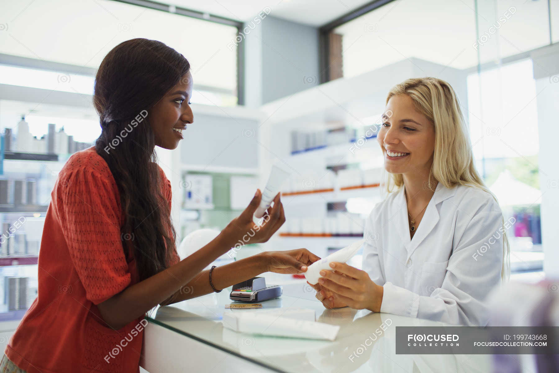Woman Discussing Skincare Product With Pharmacist In Drugstore