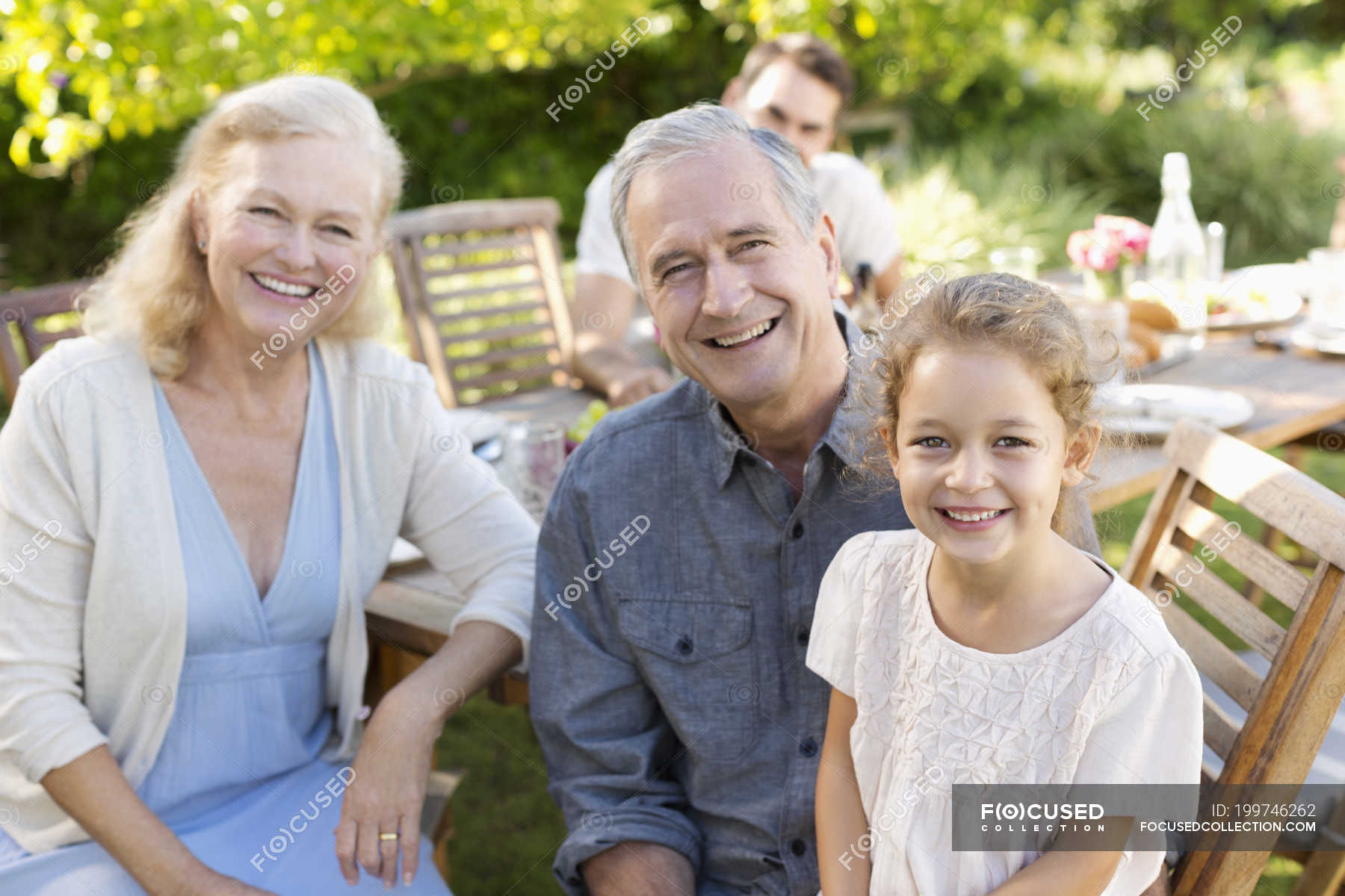 Older couple and granddaughter smiling outdoors — girl, happiness ...