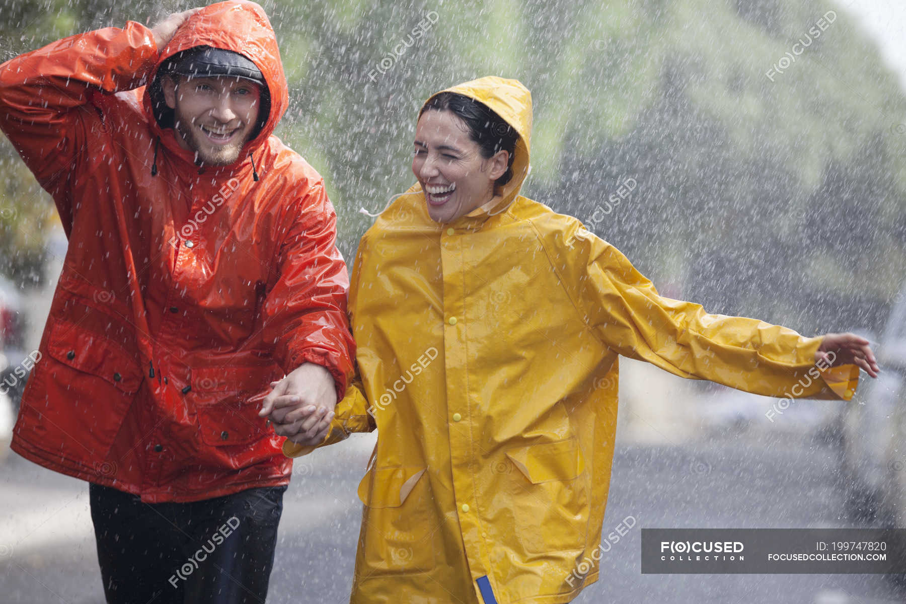 couple holding hands in rain