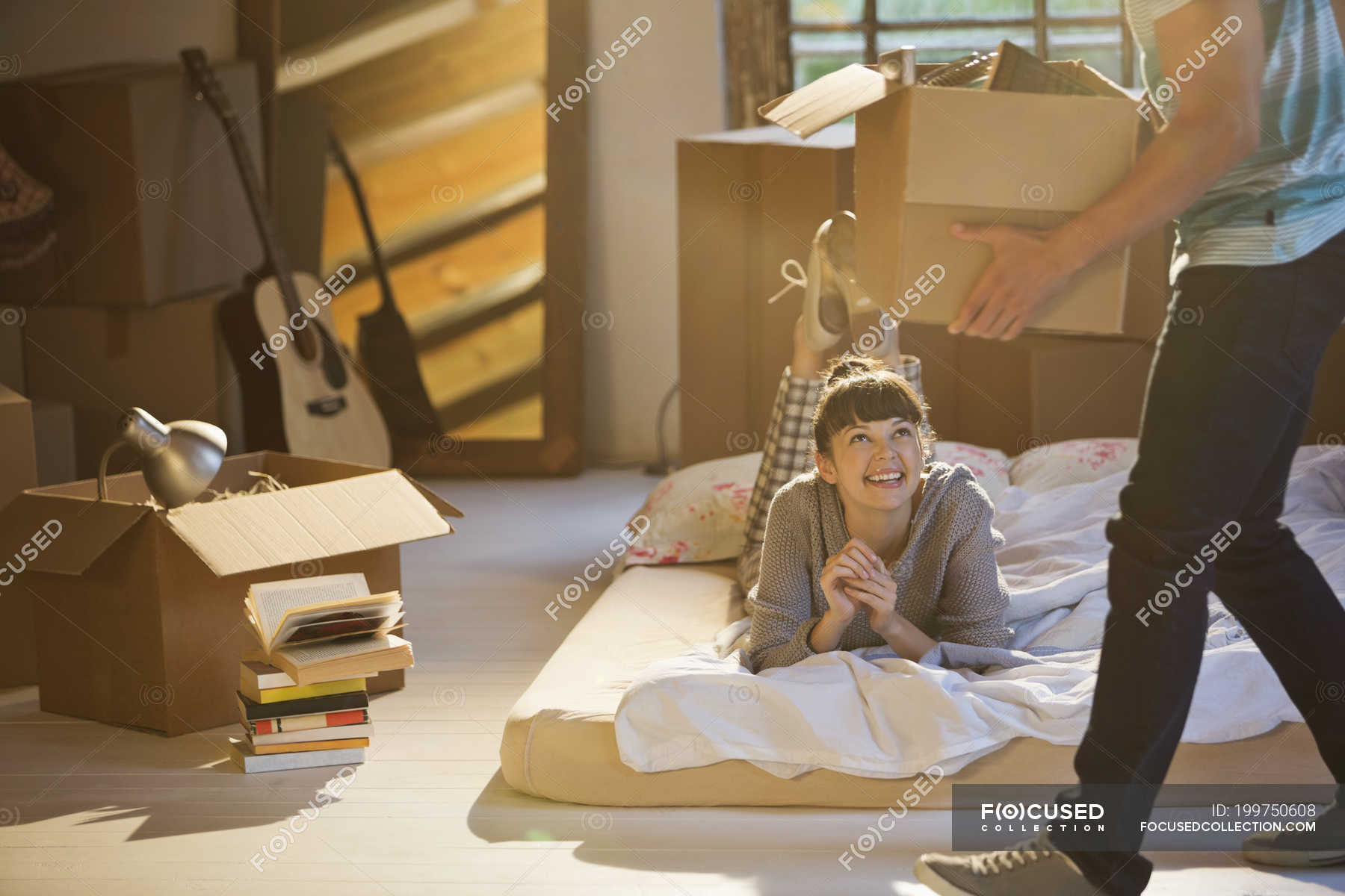 Young couple unpacking boxes in attic — young adult, looking up Stock