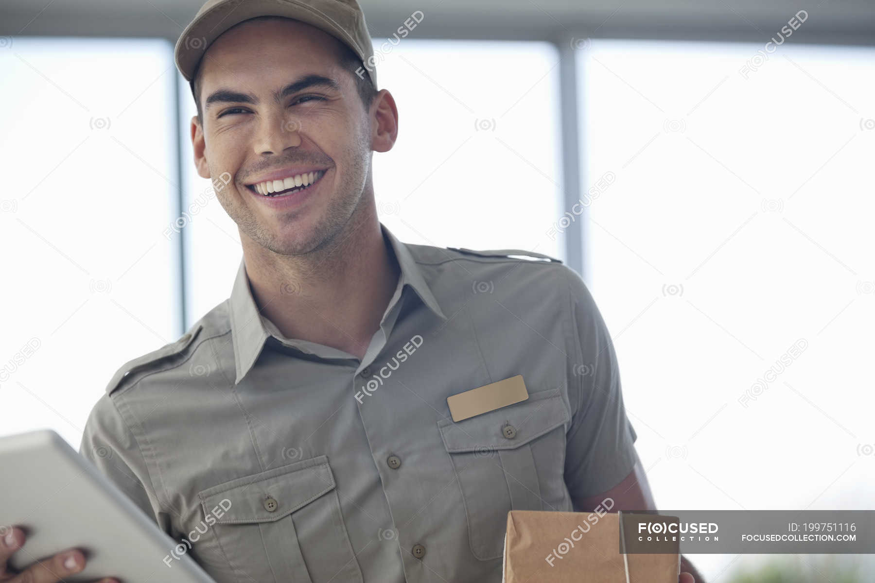 delivery-boy-smiling-with-package-at-modern-office-happiness