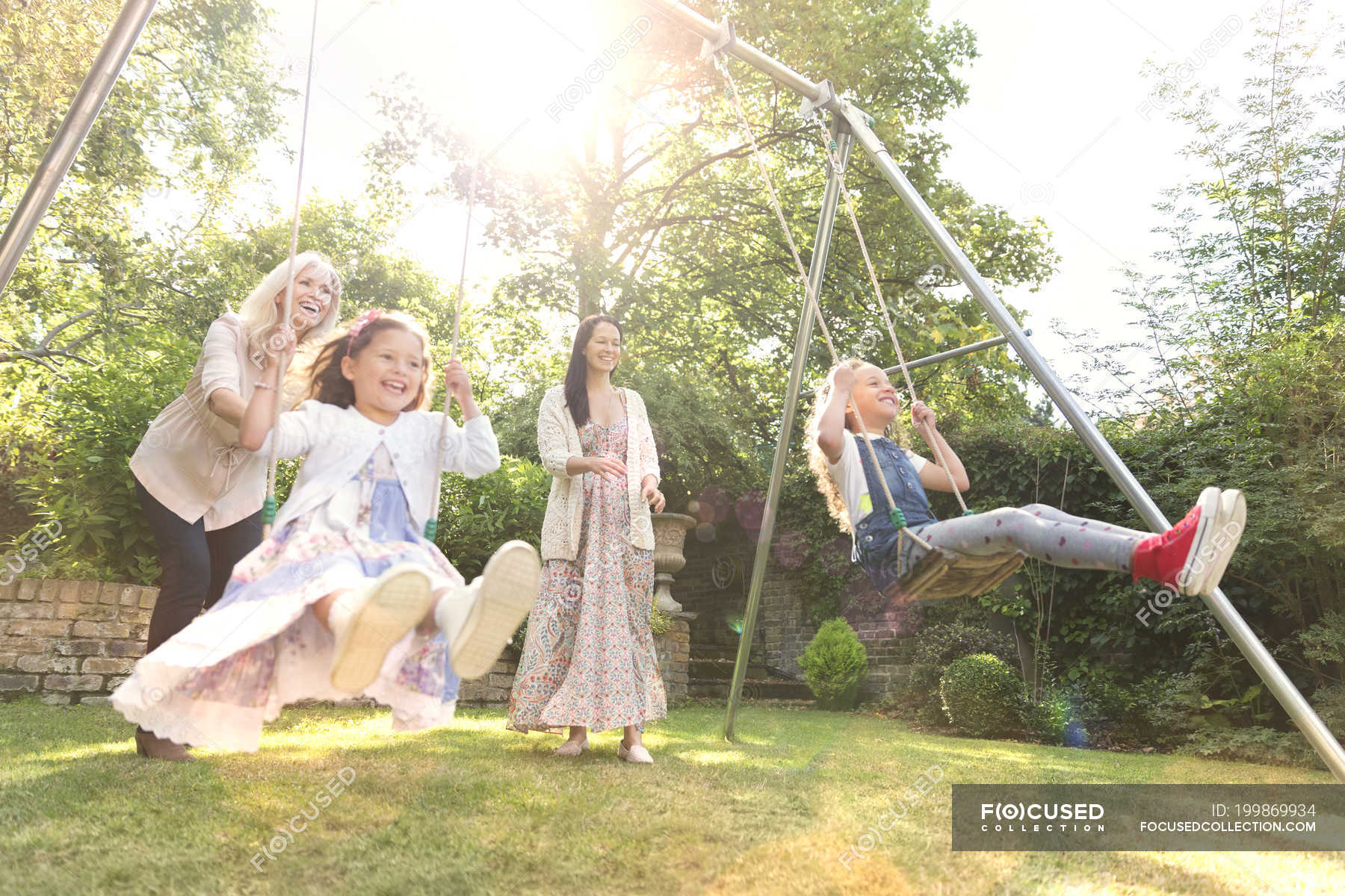 Carefree Multi Generation Women Swinging In Backyard Real