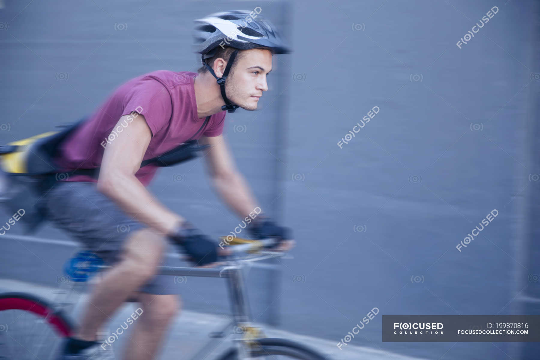 Focused bicycle messenger with helmet on the move — City Street