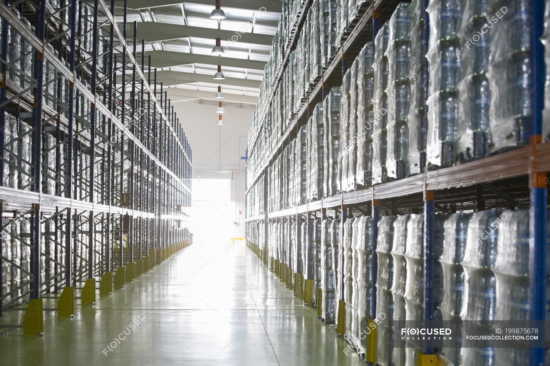 Paletas de botellas de agua en estantes de almacén — día, Agua mineral