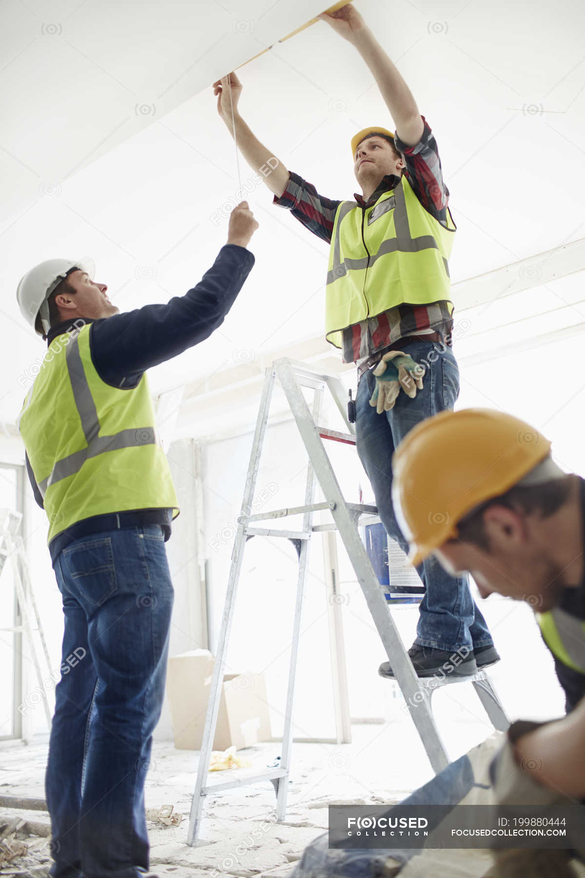 Construction worker on ladder at construction site — working, arms