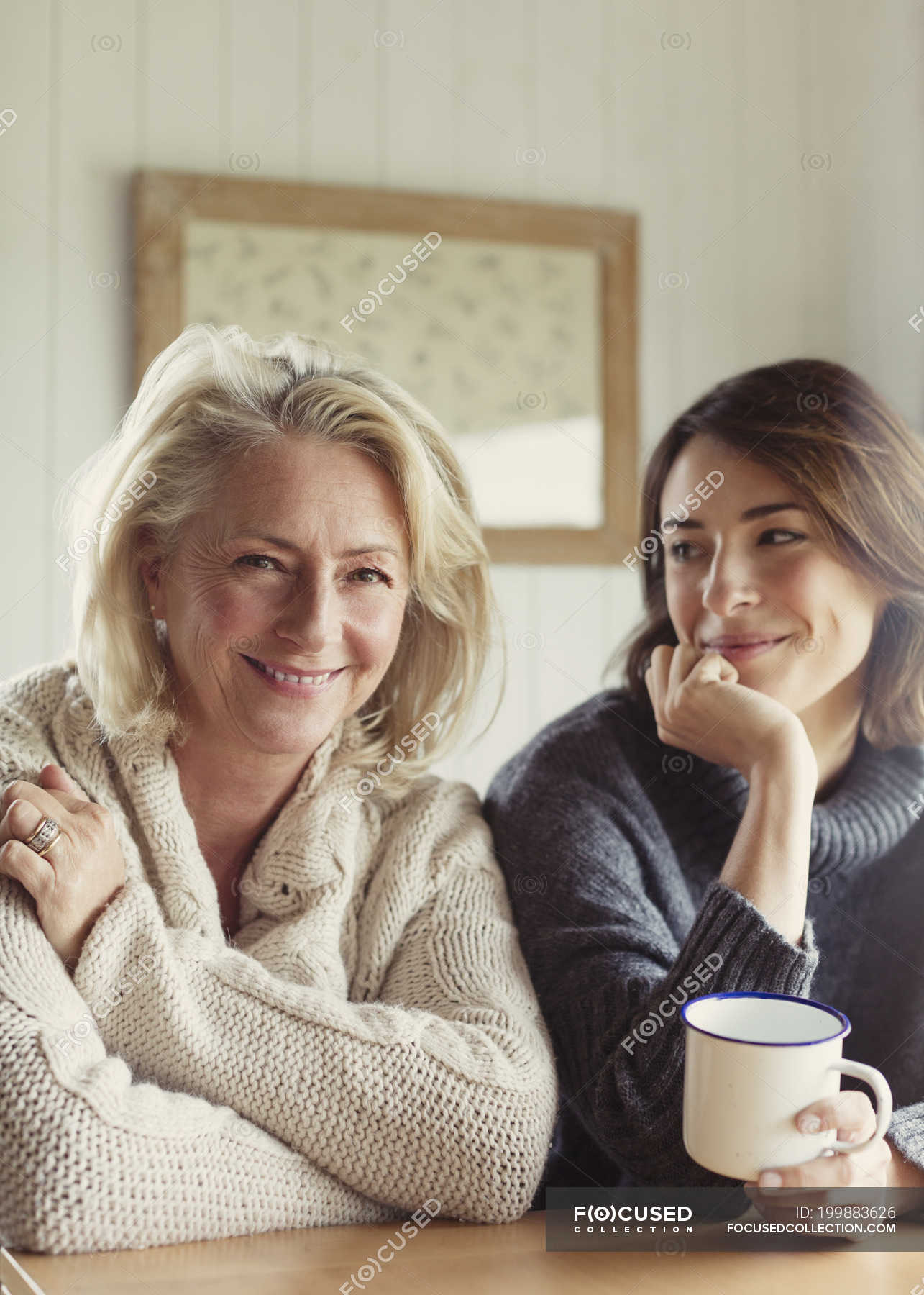 Portrait smiling mother and daughter in sweaters drinking coffee — Arms ...