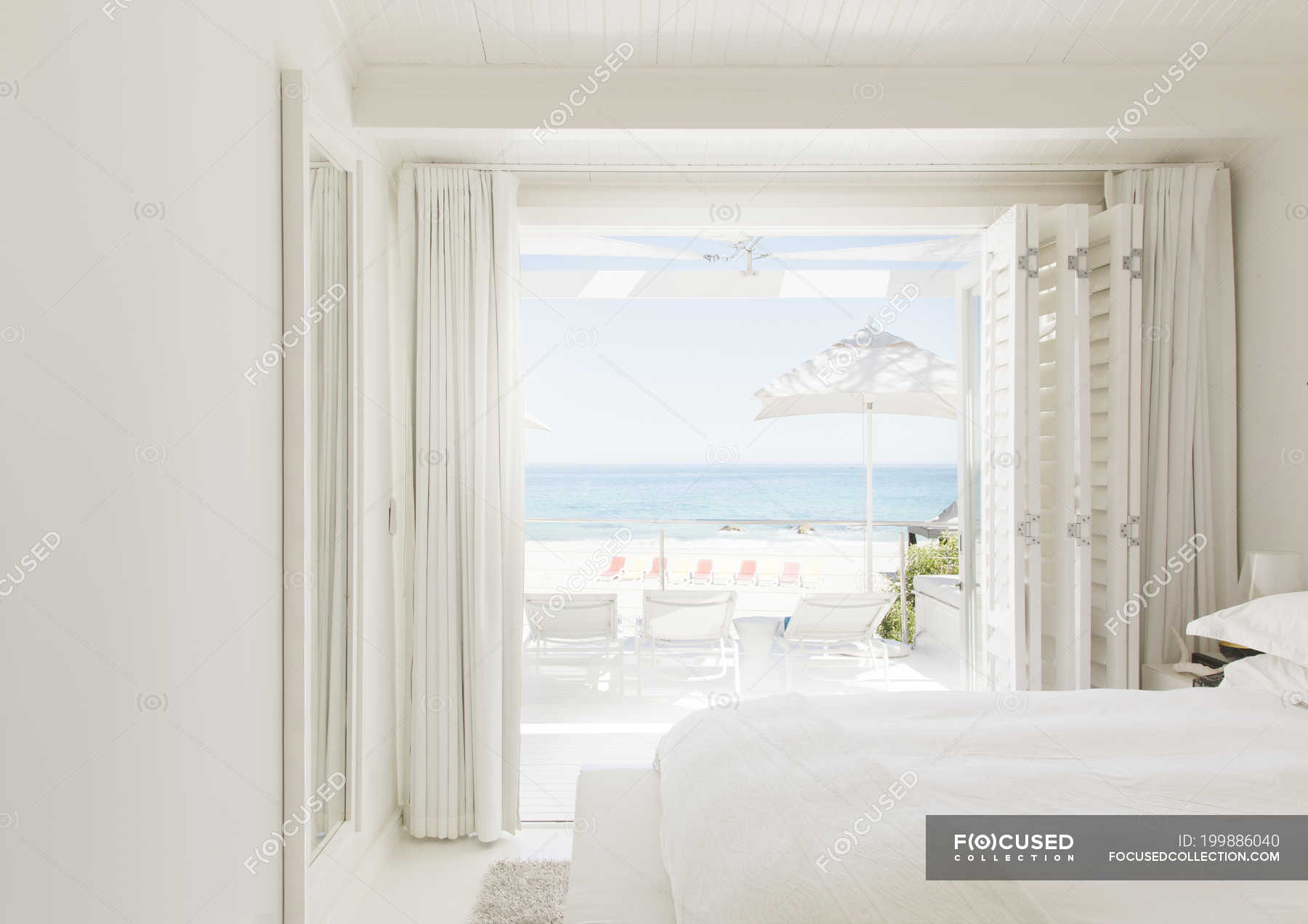 Modern bedroom overlooking beach and ocean — open, luxury Stock Photo 199886040