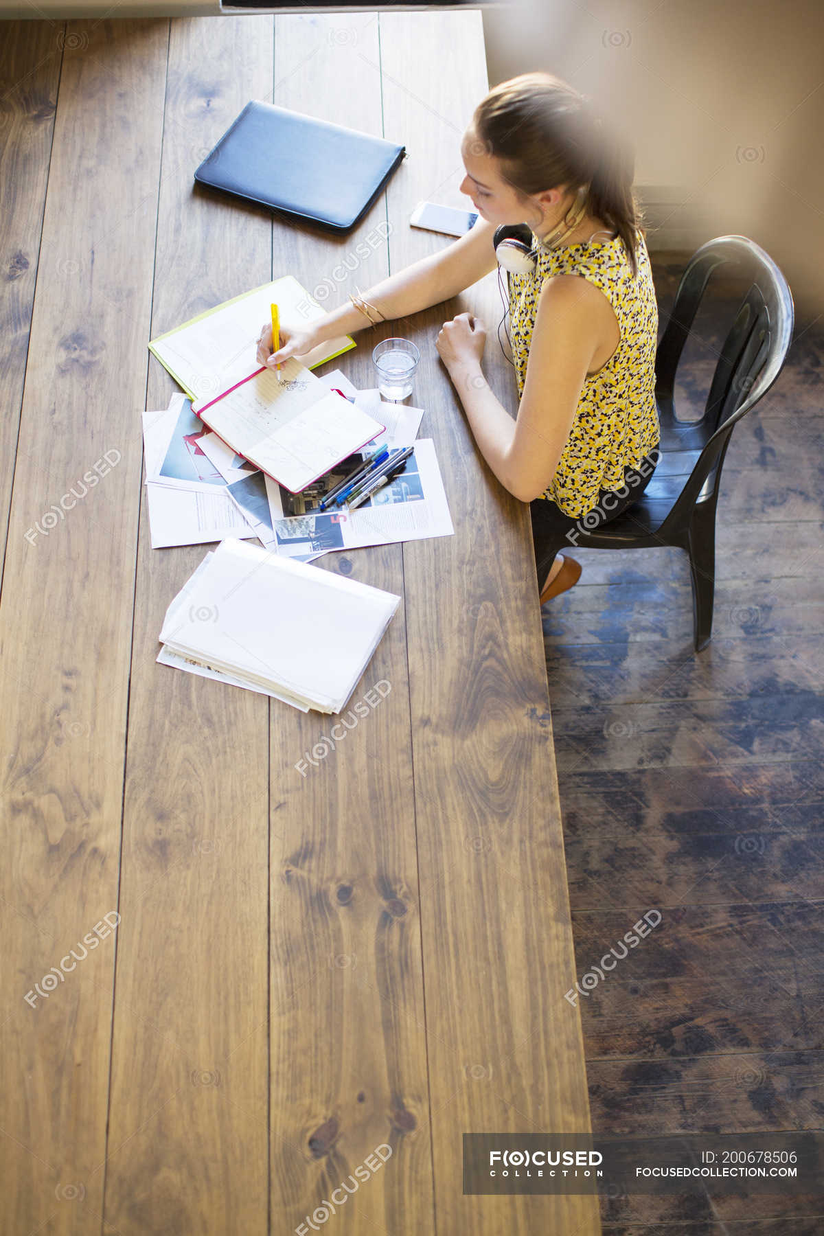 Creative businesswoman writing in notebook at table in office