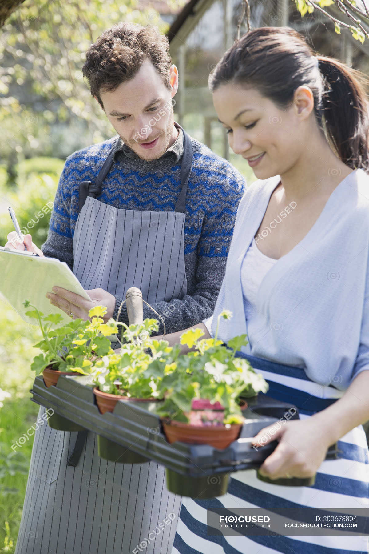 plant-nursery-workers-with-clipboard-and-potted-plants-man-business