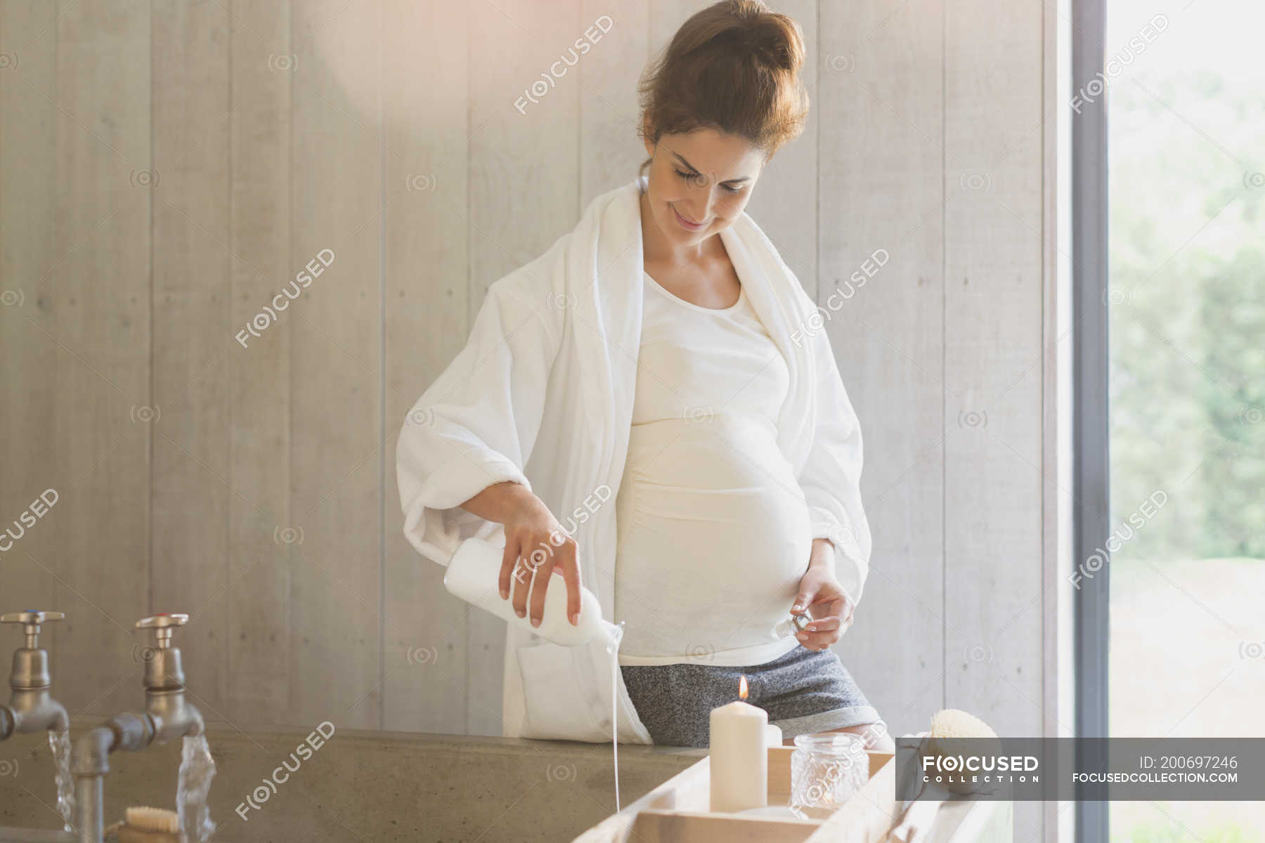 Pregnant woman preparing bubble bath — one person Stock