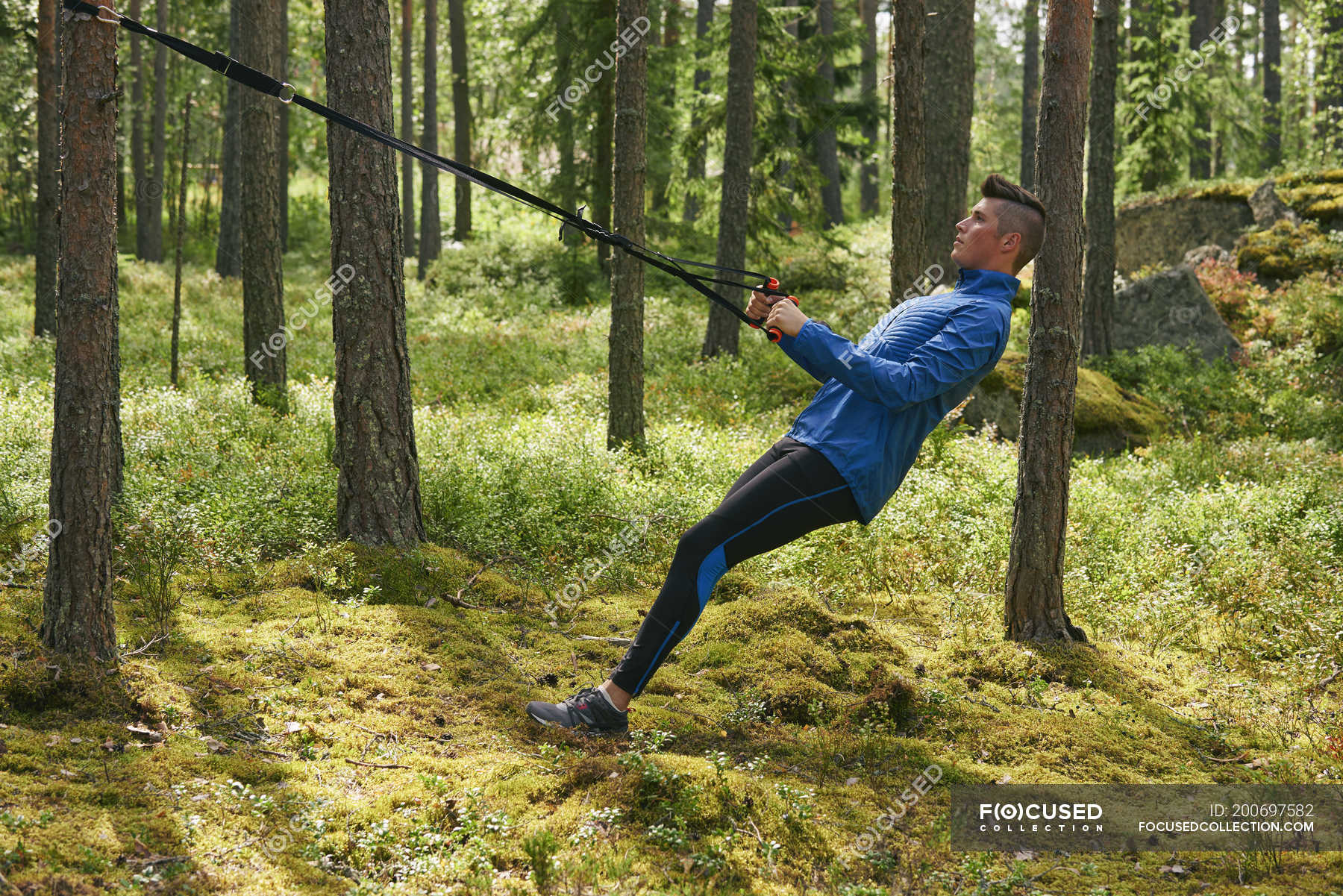 Runner using resistance band on tree in 