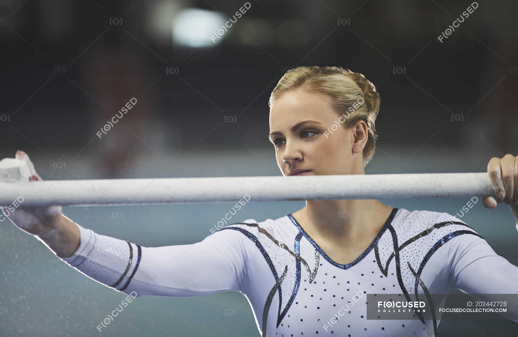 Female gymnast using chalk on uneven bars in arena — fit, gymnastics Stock Photo 202442728