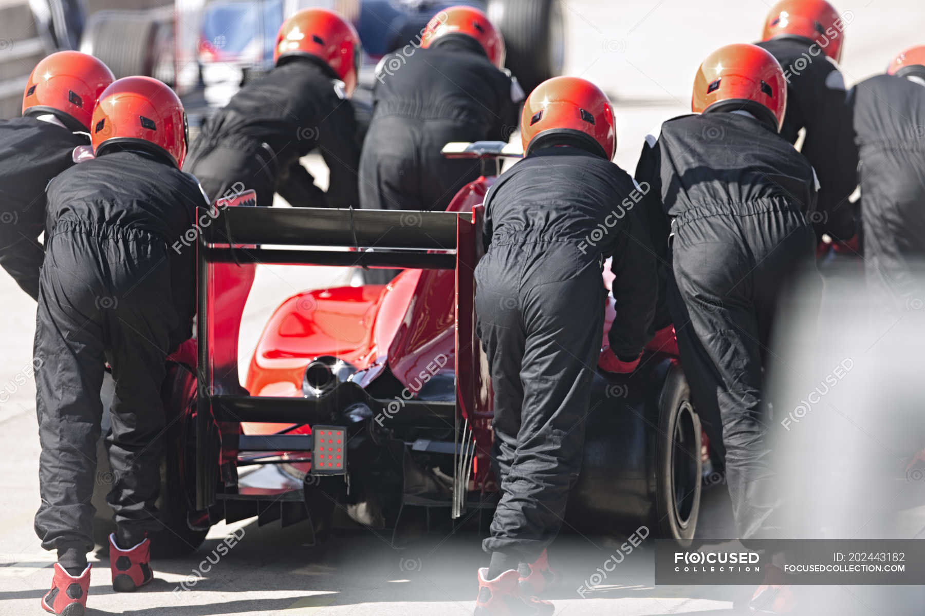 Pit crew pushing formula one race car out of pit lane — sports, f1 ...