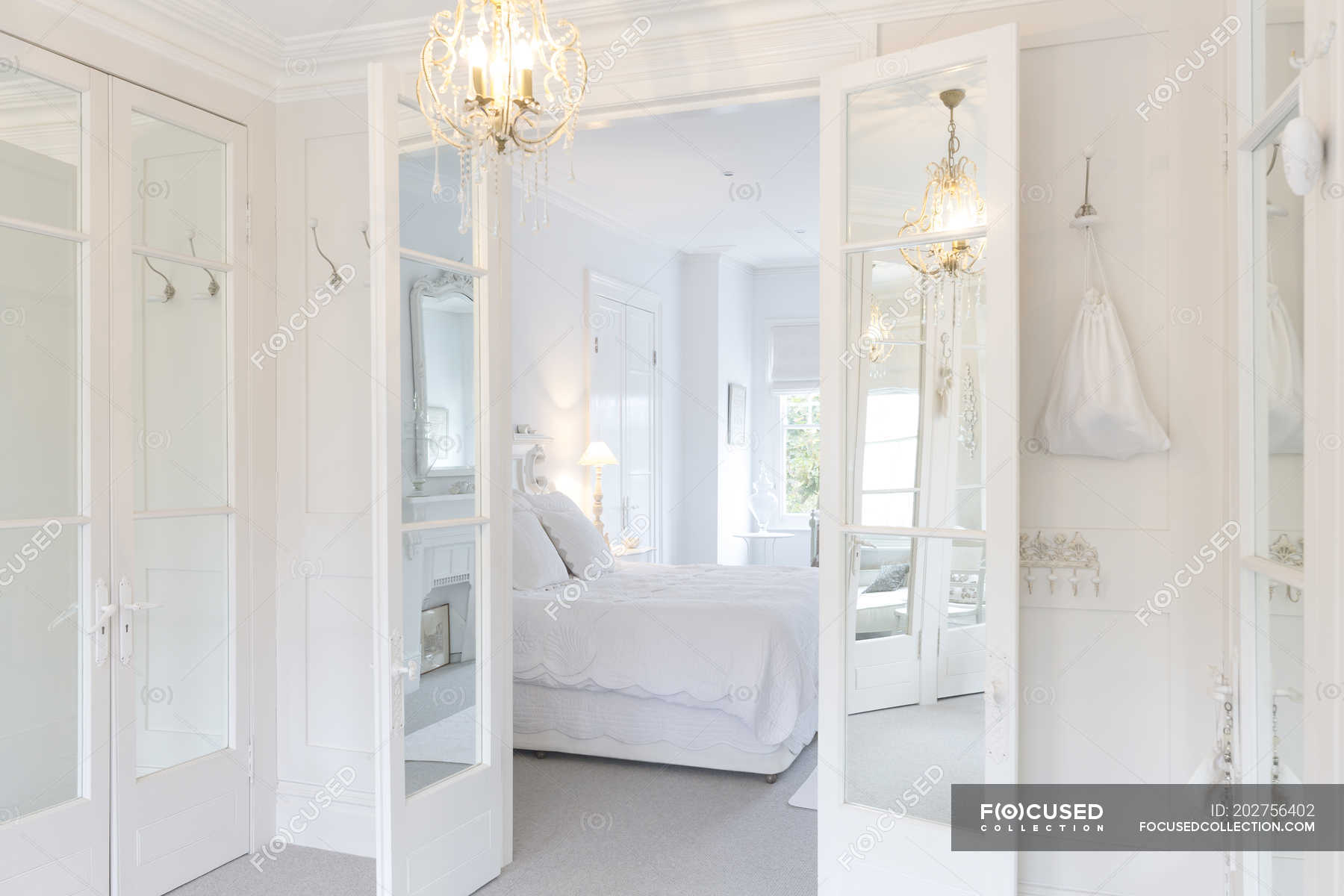 White Luxury Home Showcase Interior Bedroom With French Doors And White Luxury Home Showcase Interior Bedroom With French Doors And Chandelier Stock Photos