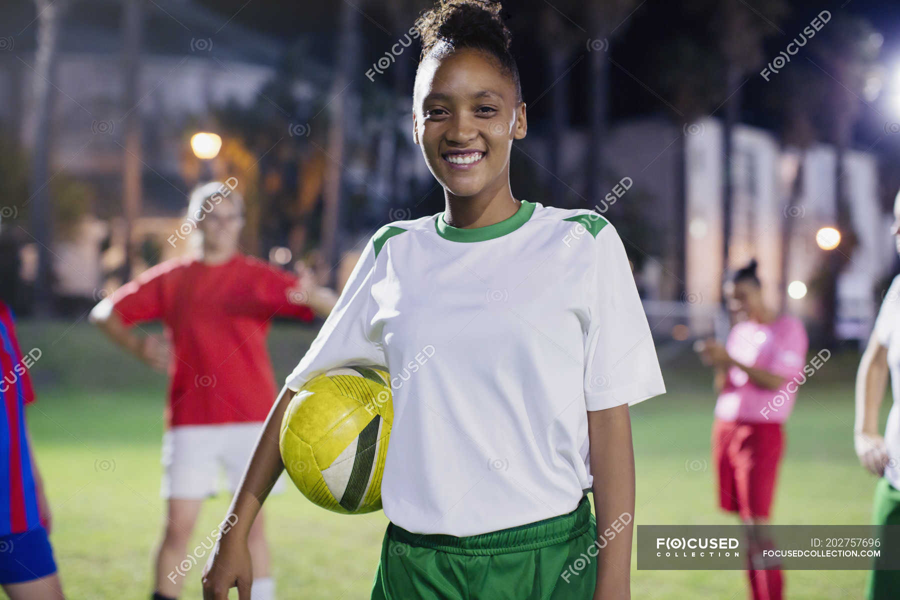 portrait-smiling-confident-young-female-soccer-player-with-ball-on