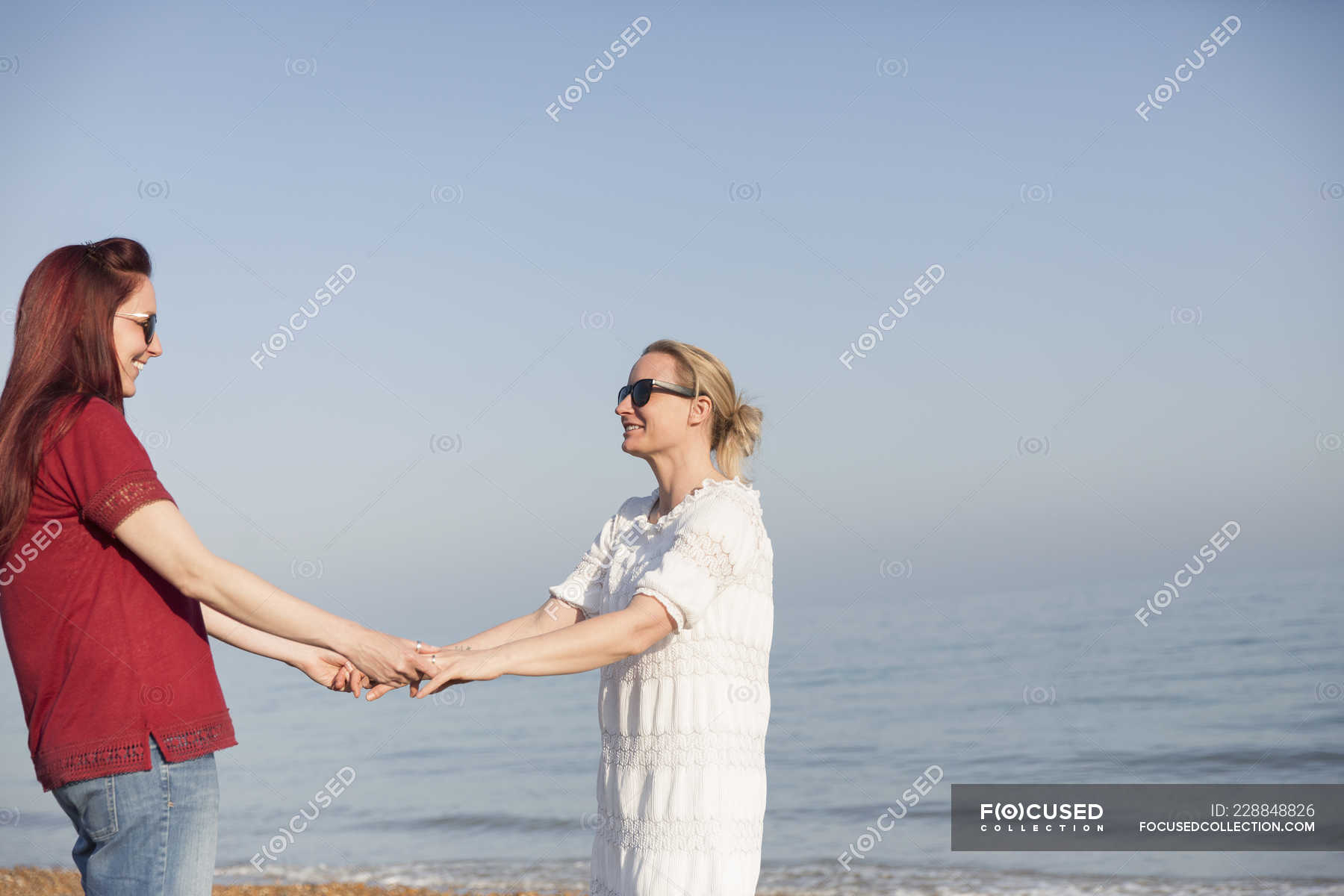 Affectionate Lesbian Couple Holding Hands On Sunny Ocean Beach — Two
