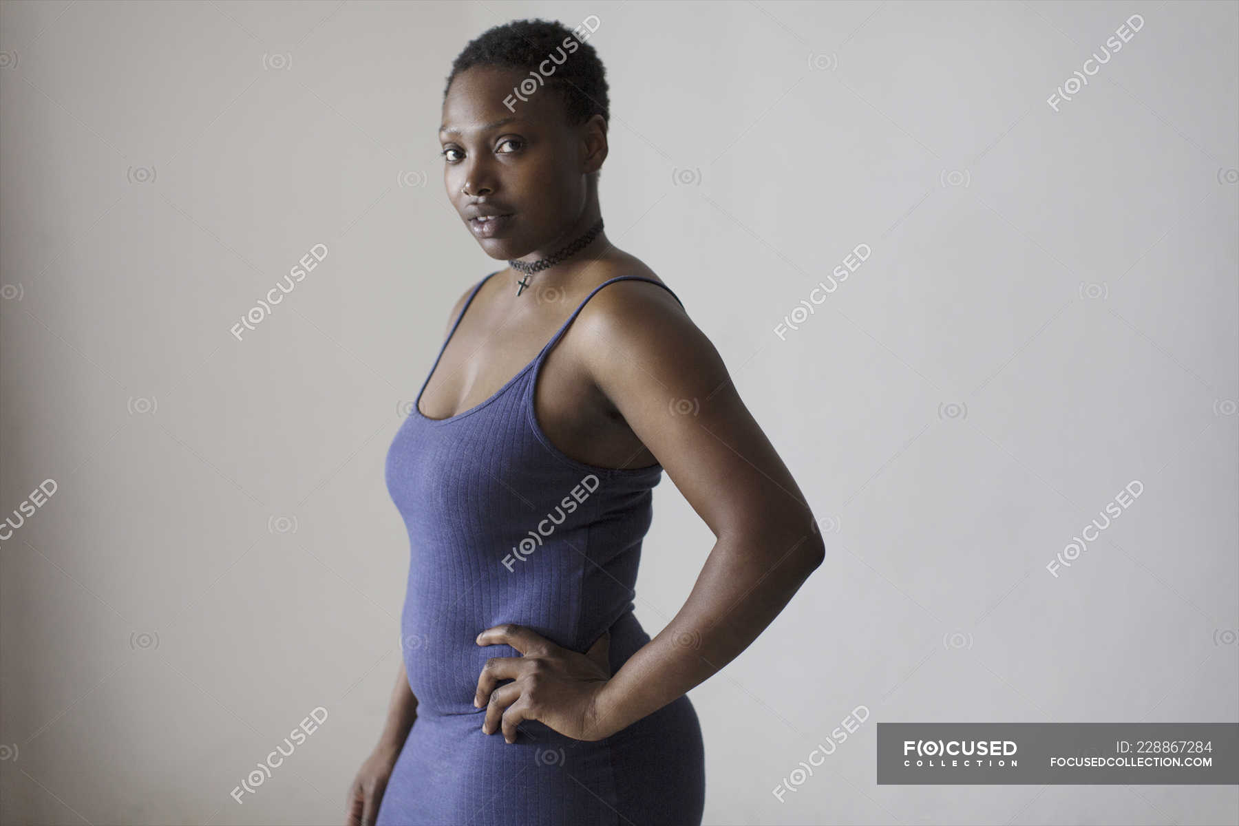 Portrait serious, confident woman with hand on hip — gray background ...