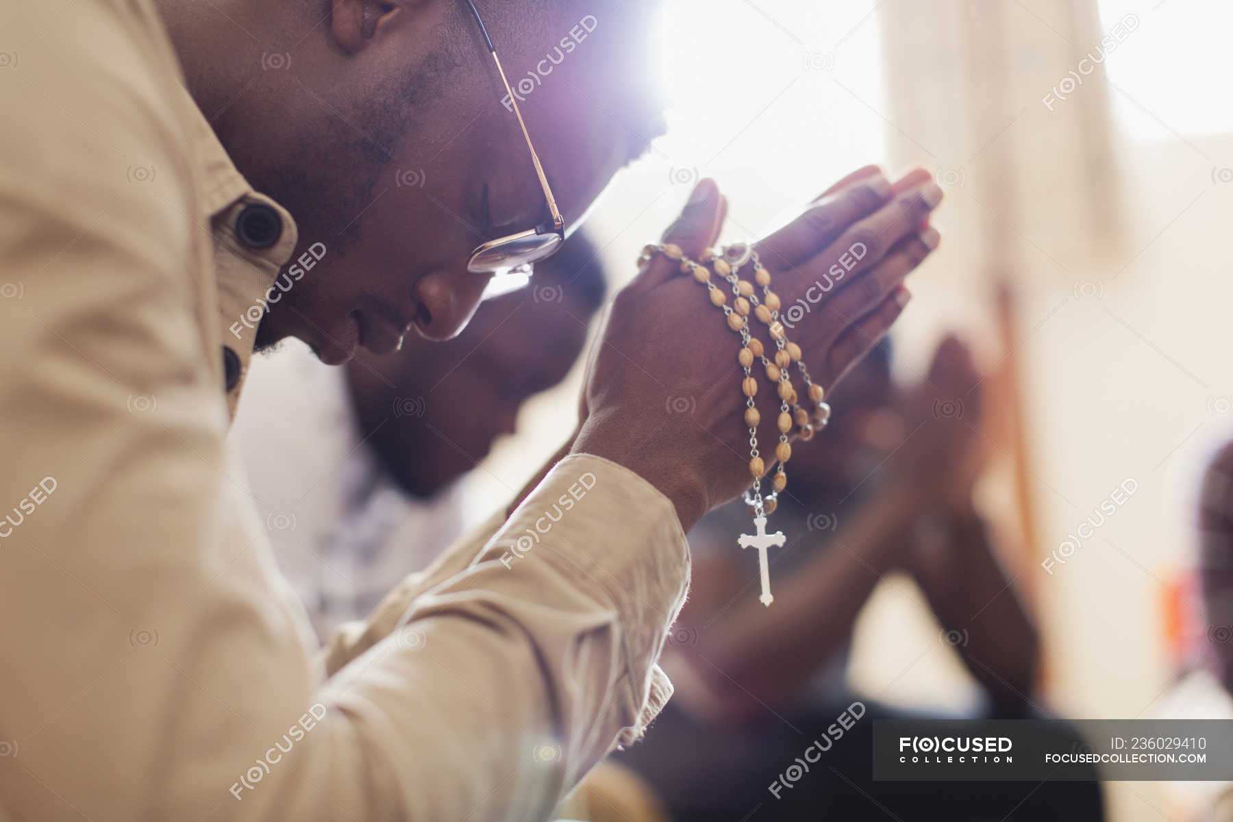 Man praying with rosary in prayer group — one person, Organized Group