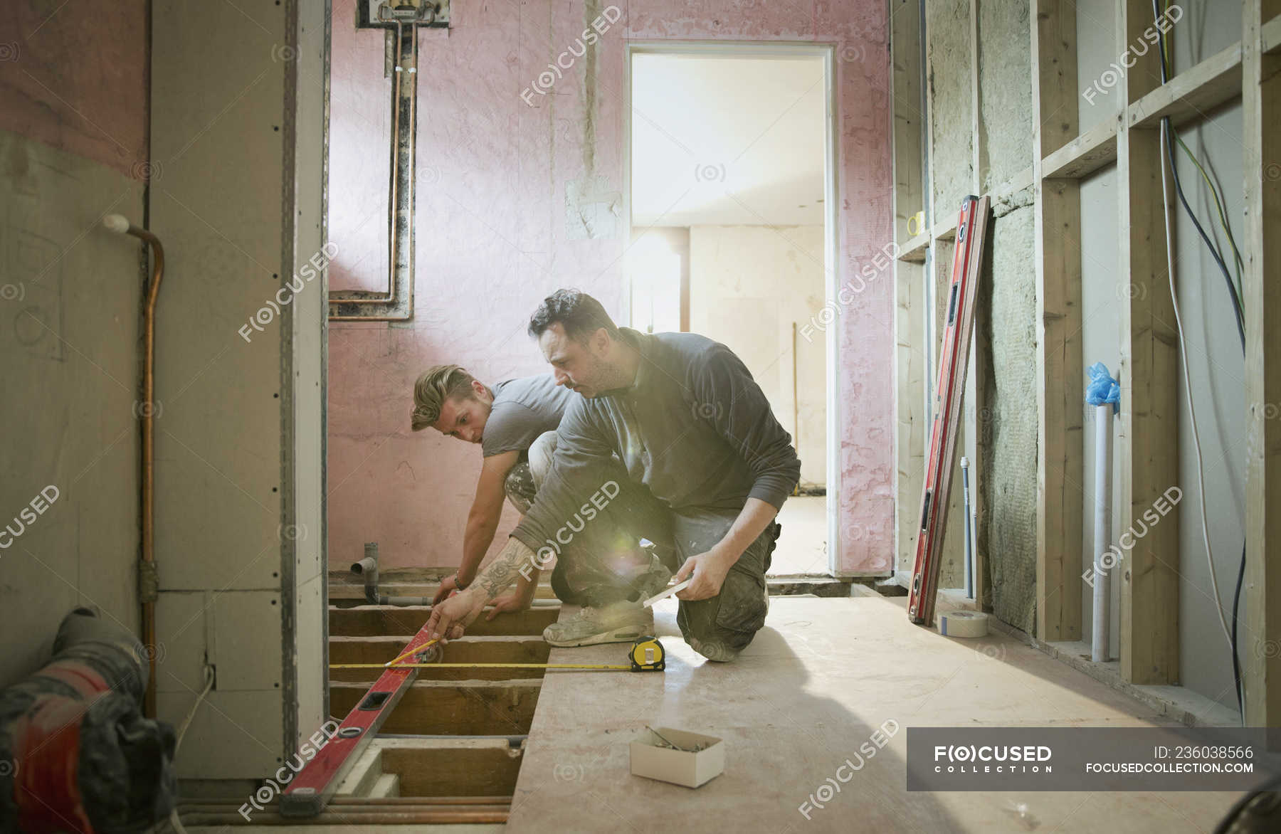 Construction workers using level tool in house — teamwork, renovation ...