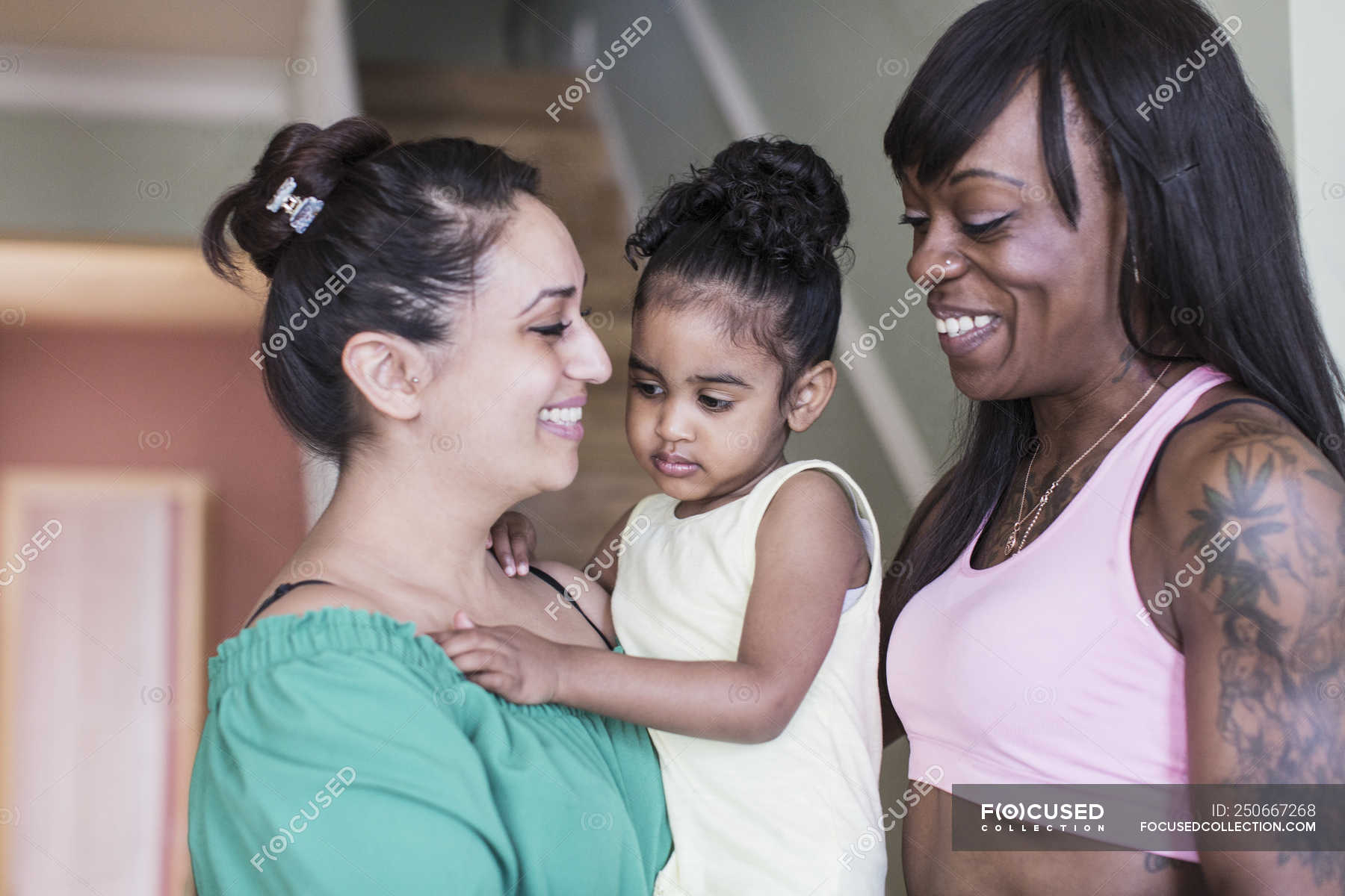 Happy lesbian couple with toddler daughter — love, young family Stock