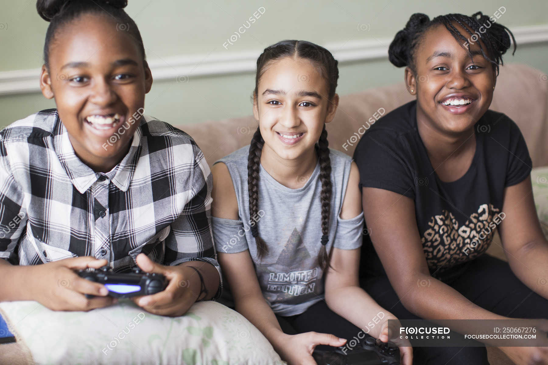 Portrait Smiling Tween Girl Friends Playing Video Game On Sofa