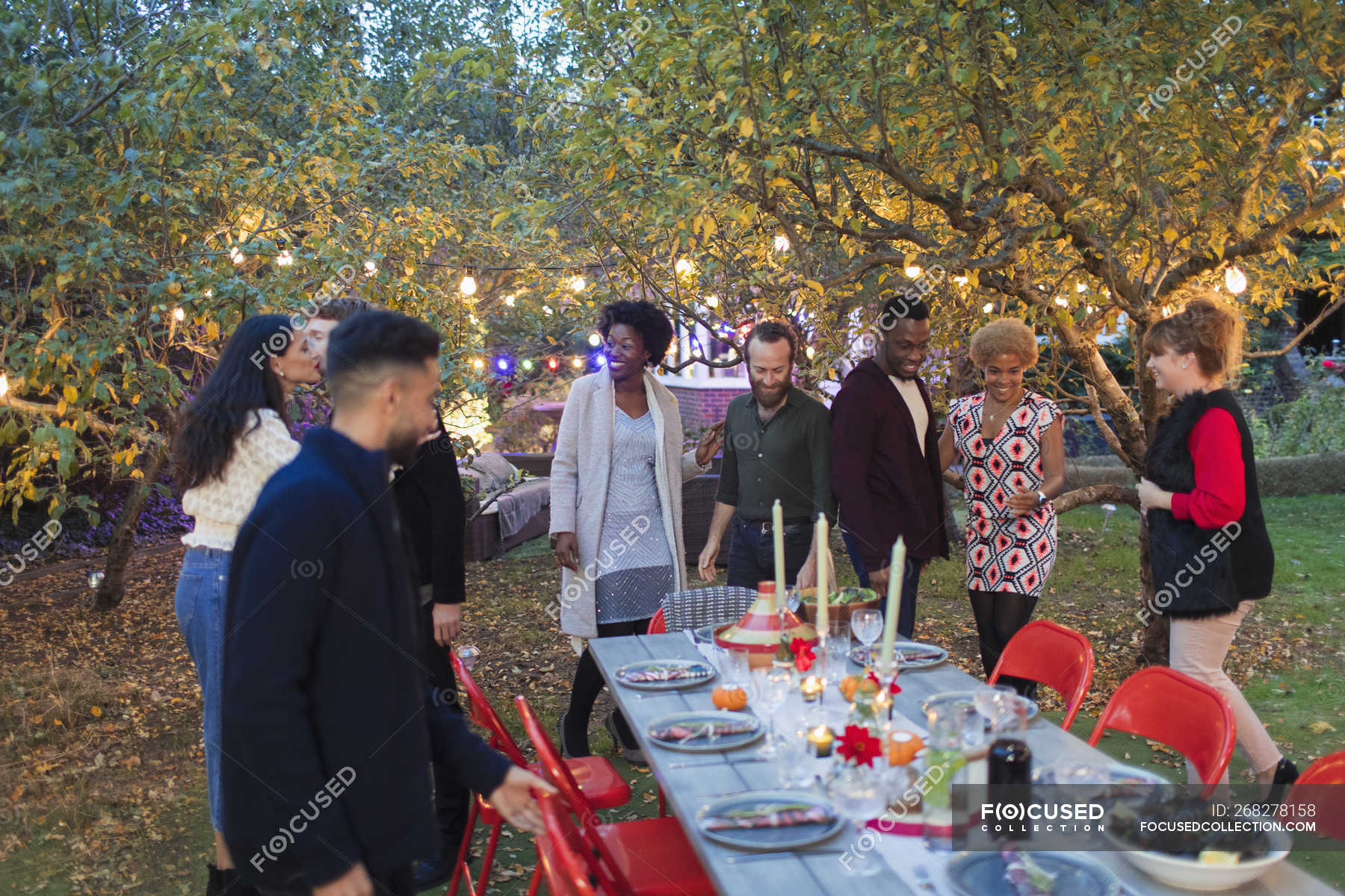 Friends arriving for dinner garden party — fairy light, people - Stock ...