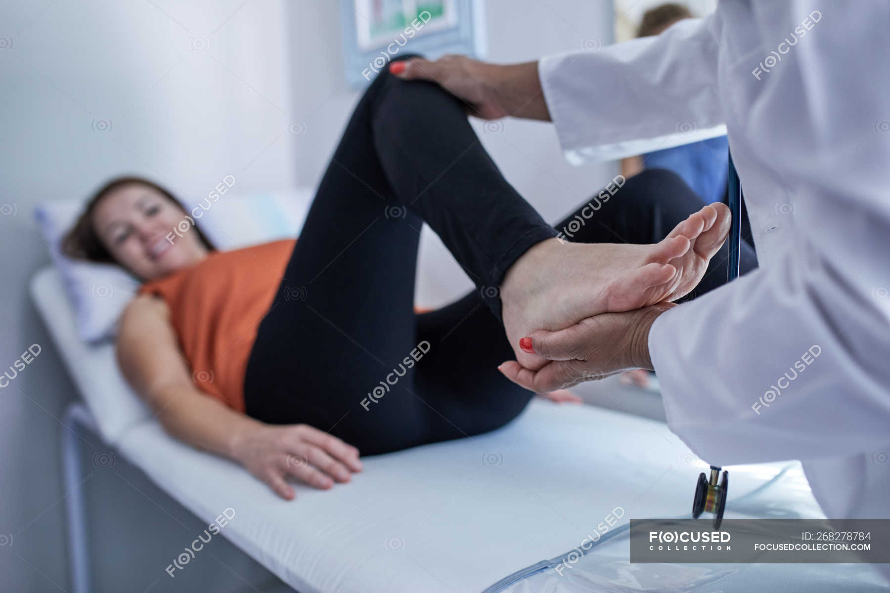 реабилитация после травмы. врач и пациентка. конечности пациентка. реабилитация после травмы. доктор осматривает ноги.