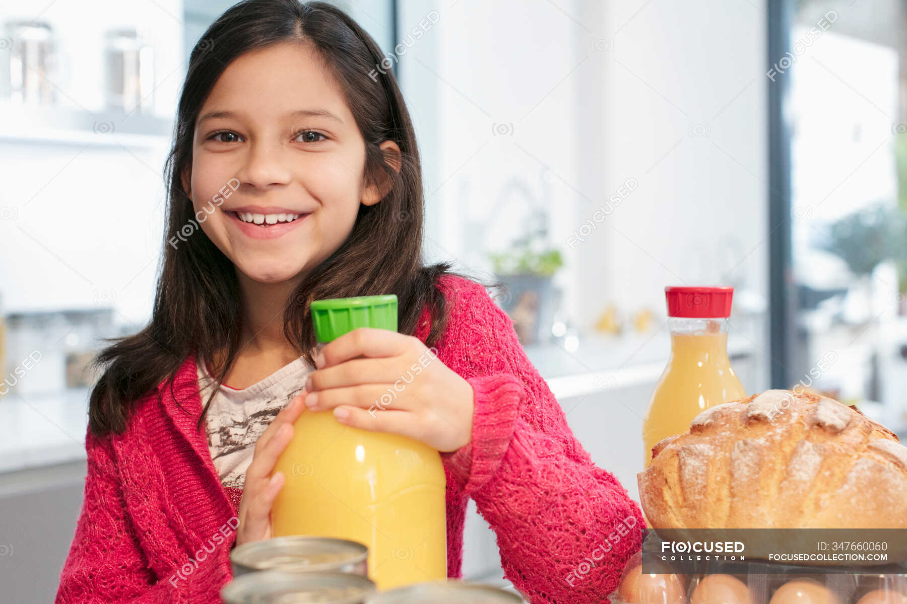 portrait-smiling-girl-with-orange-juice-in-kitchen-horizontal